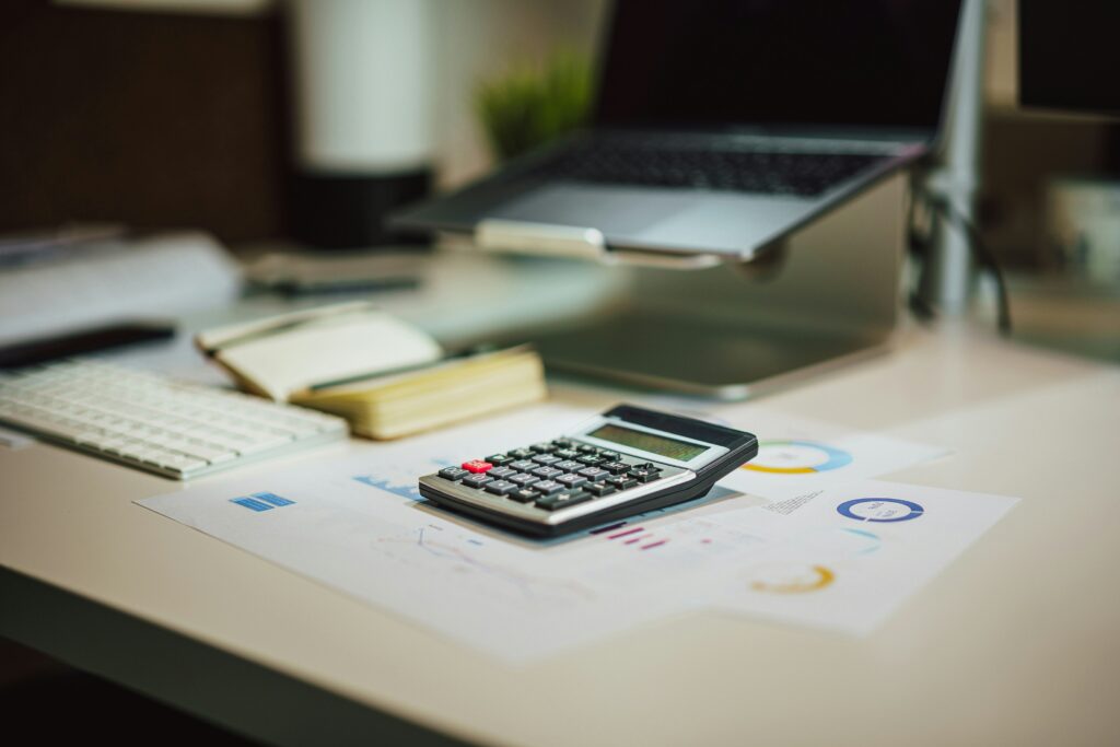 calculator next to bills on table for debt payment calculation