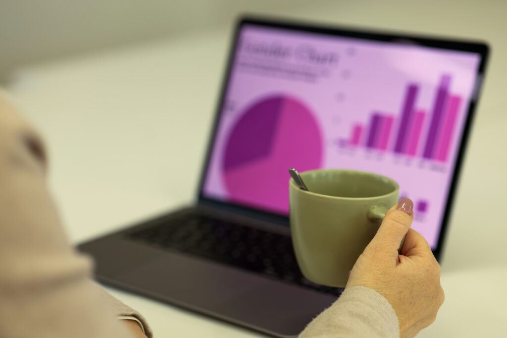 person reviewing bank statement on laptop with coffee